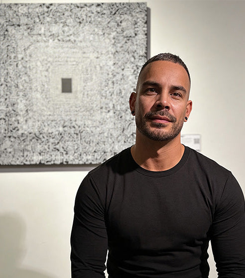 Jafeth Sitting in front of his artwork