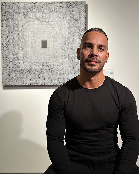 Jafeth Sitting in front of his artwork