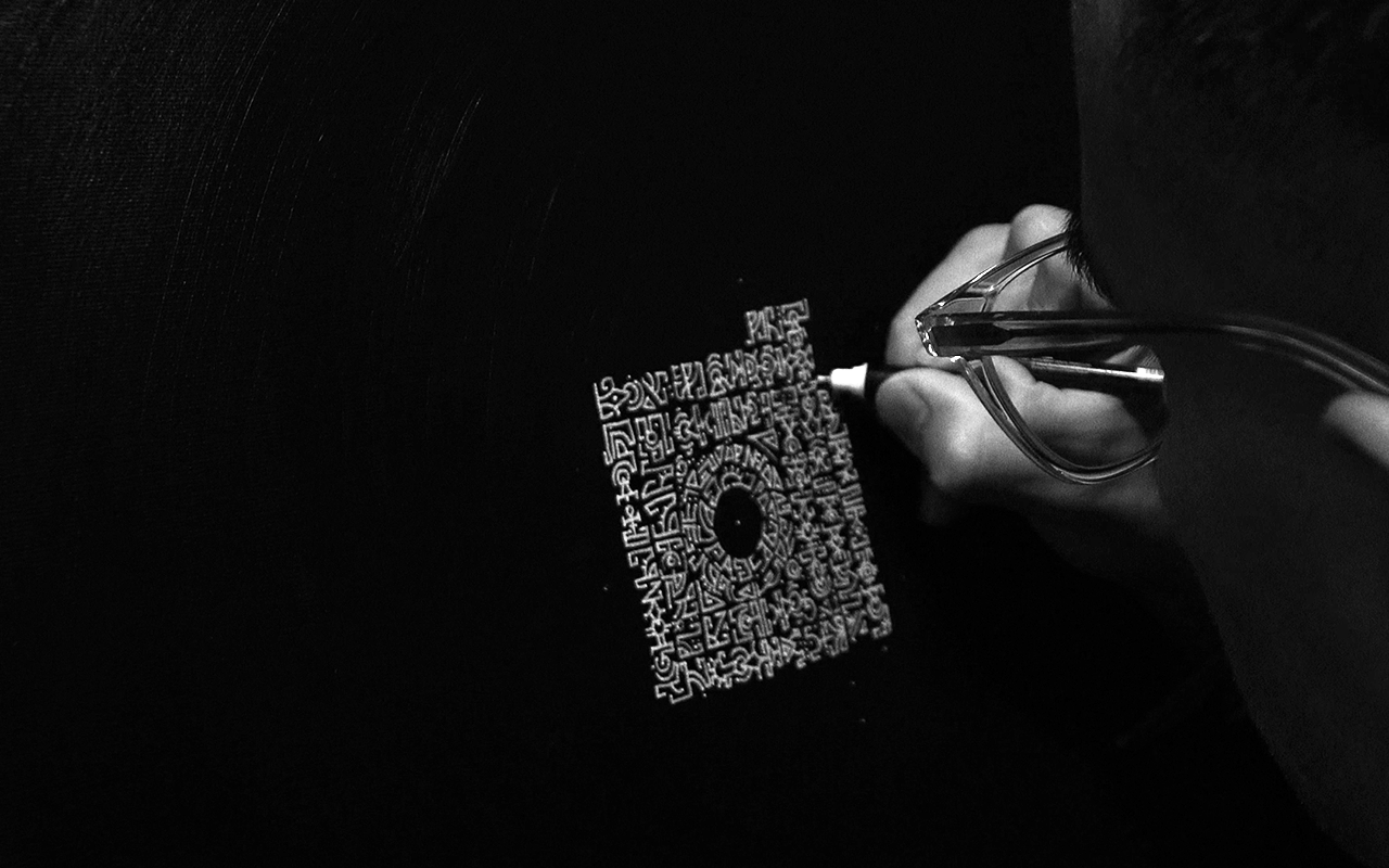 Black and white image of Jafeth holding a posca pen creating art